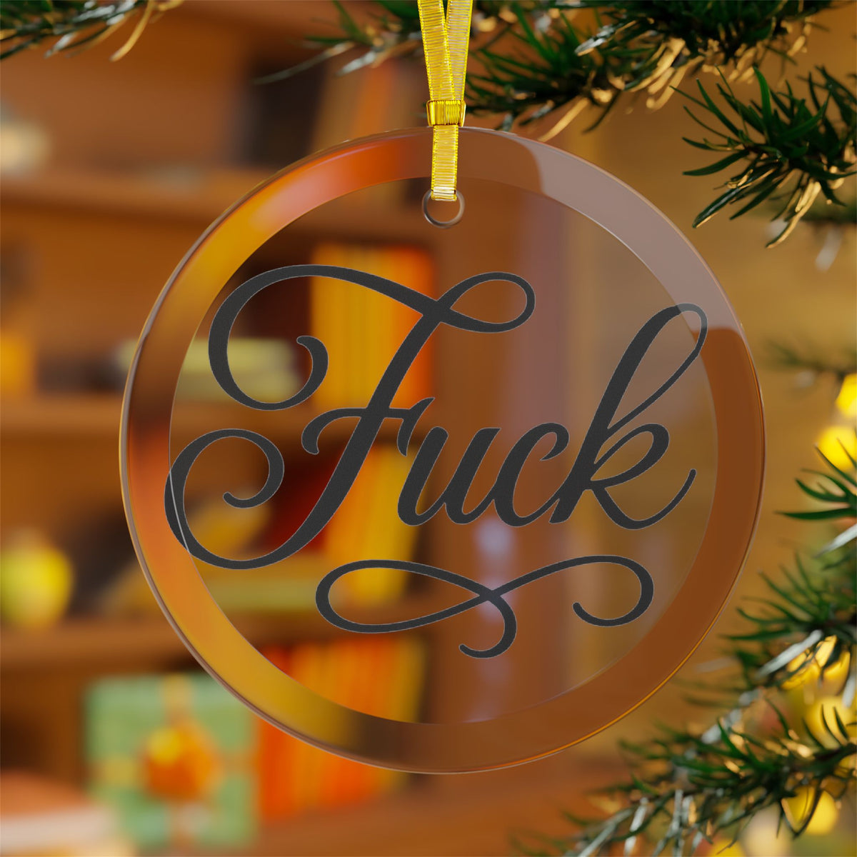 Clear round glass ornament with black script FUCK lettering and gold ribbon