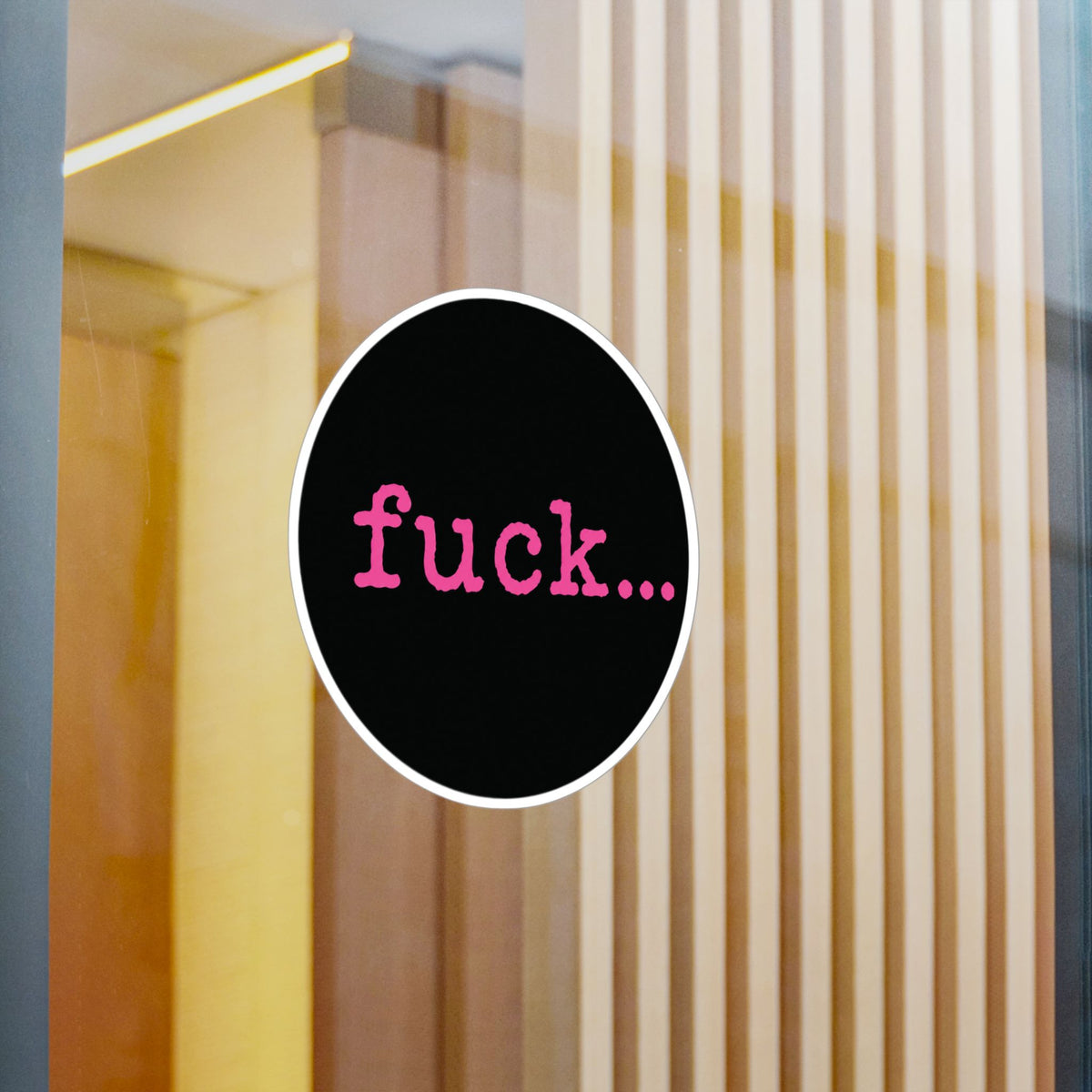 Round black vinyl sticker with lowercase motel-pink fuck and an ellipsis
