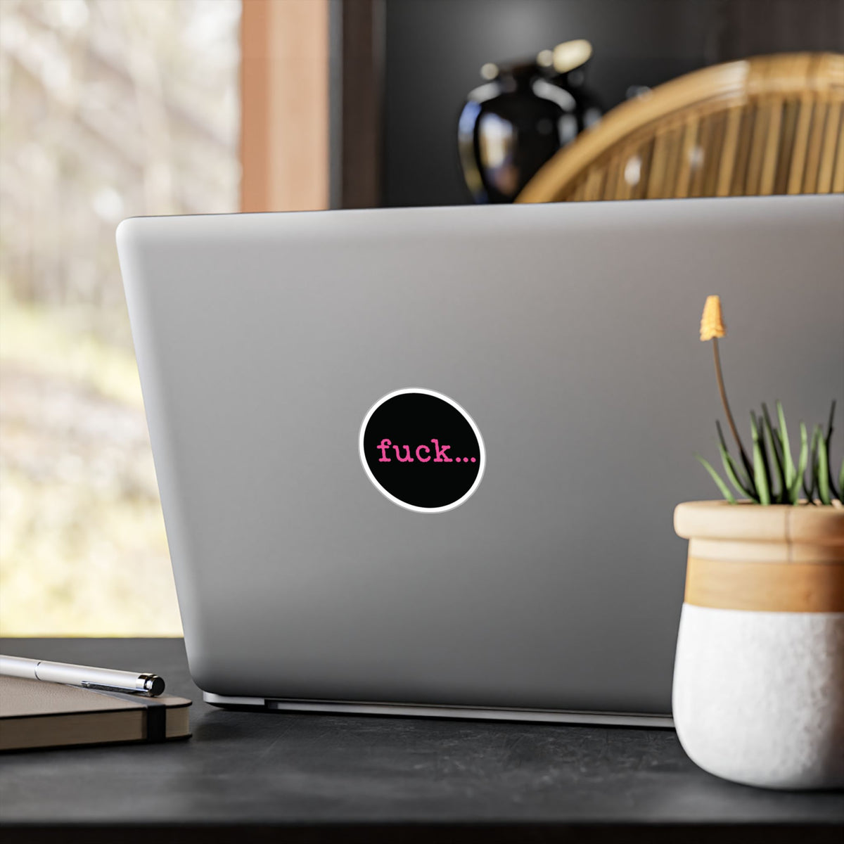 Round black vinyl sticker with lowercase motel-pink fuck and an ellipsis