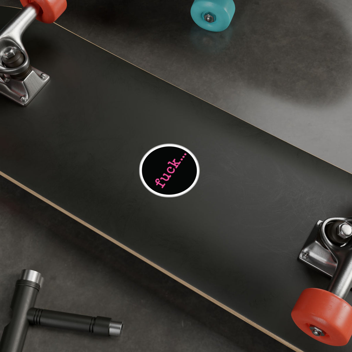 Round black vinyl sticker with lowercase motel-pink fuck and an ellipsis