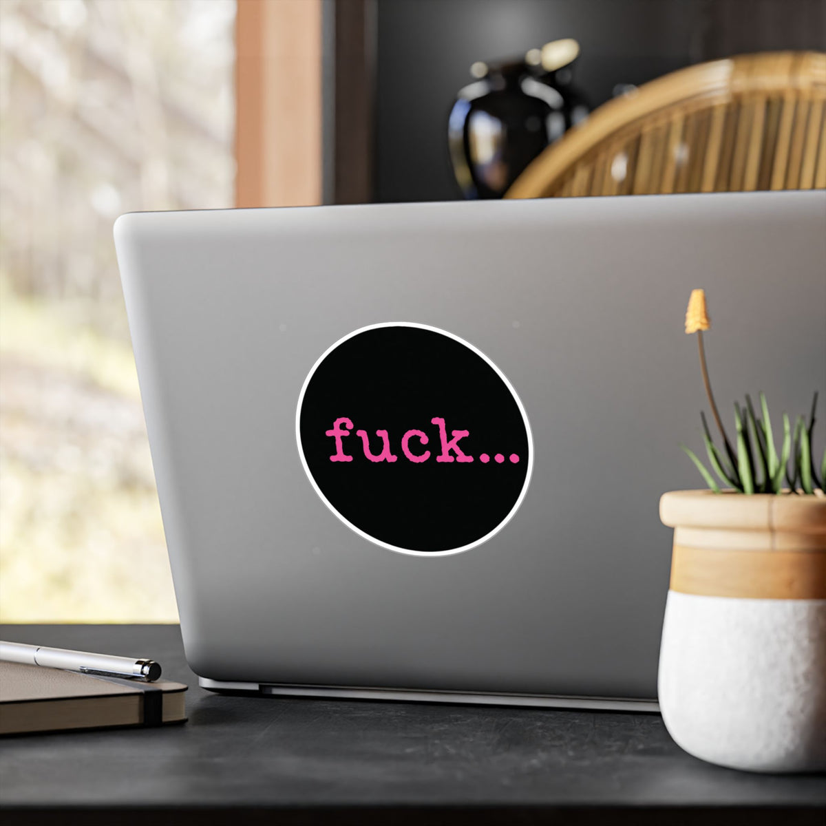 Round black vinyl sticker with lowercase motel-pink fuck and an ellipsis