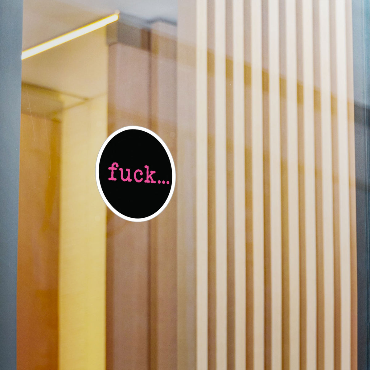 Round black vinyl sticker with lowercase motel-pink fuck and an ellipsis