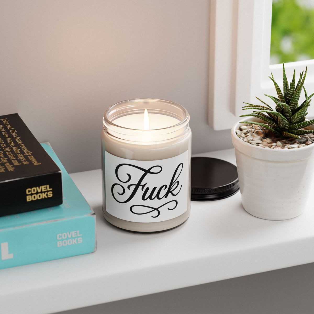 Nine-ounce glass soy candle with black lid and black script FUCK label