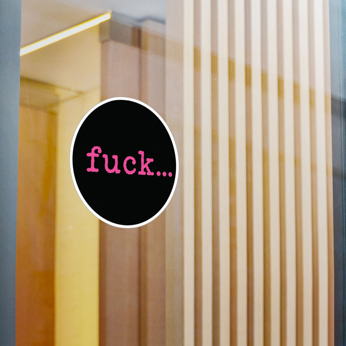 Round black vinyl sticker with lowercase motel-pink fuck and an ellipsis