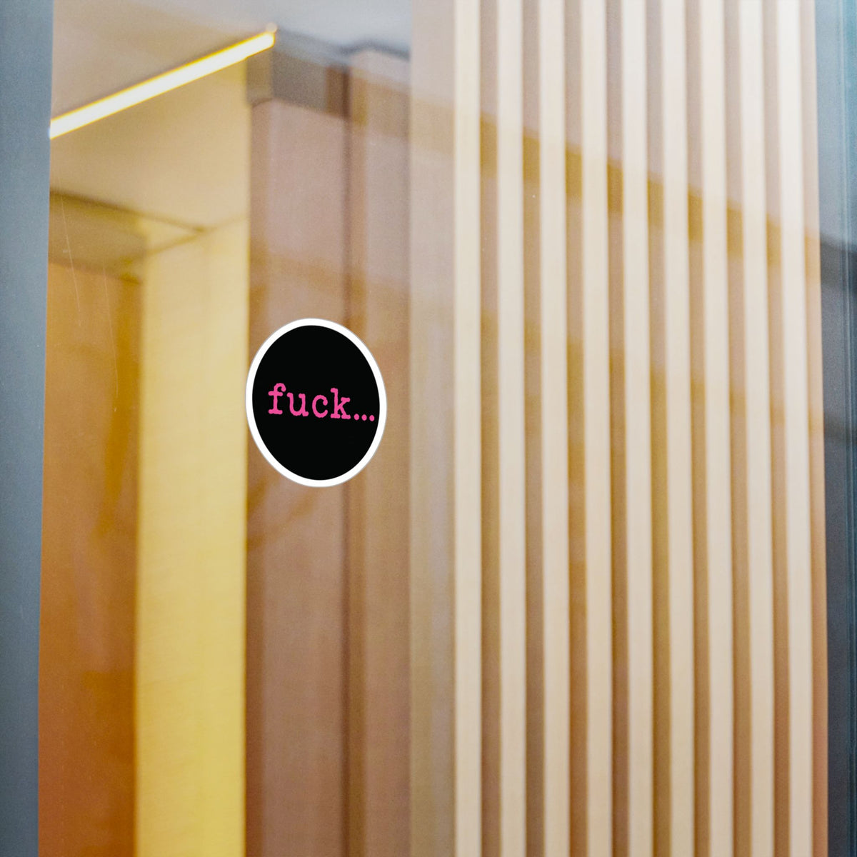 Round black vinyl sticker with lowercase motel-pink fuck and an ellipsis