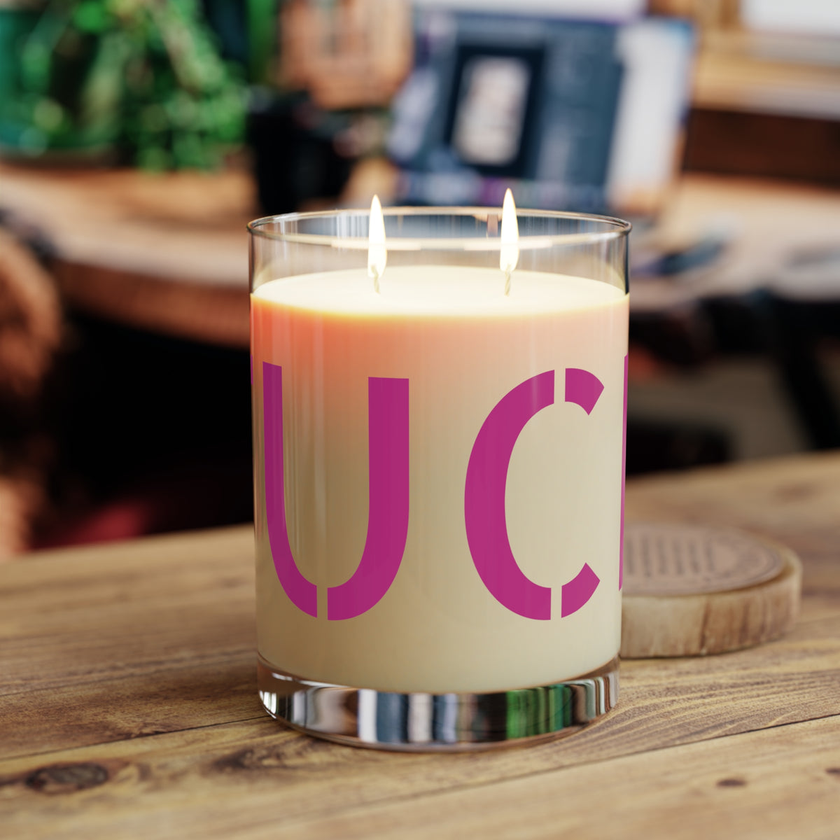Glass candle with oversized motel-pink FUCK typography on a cream label