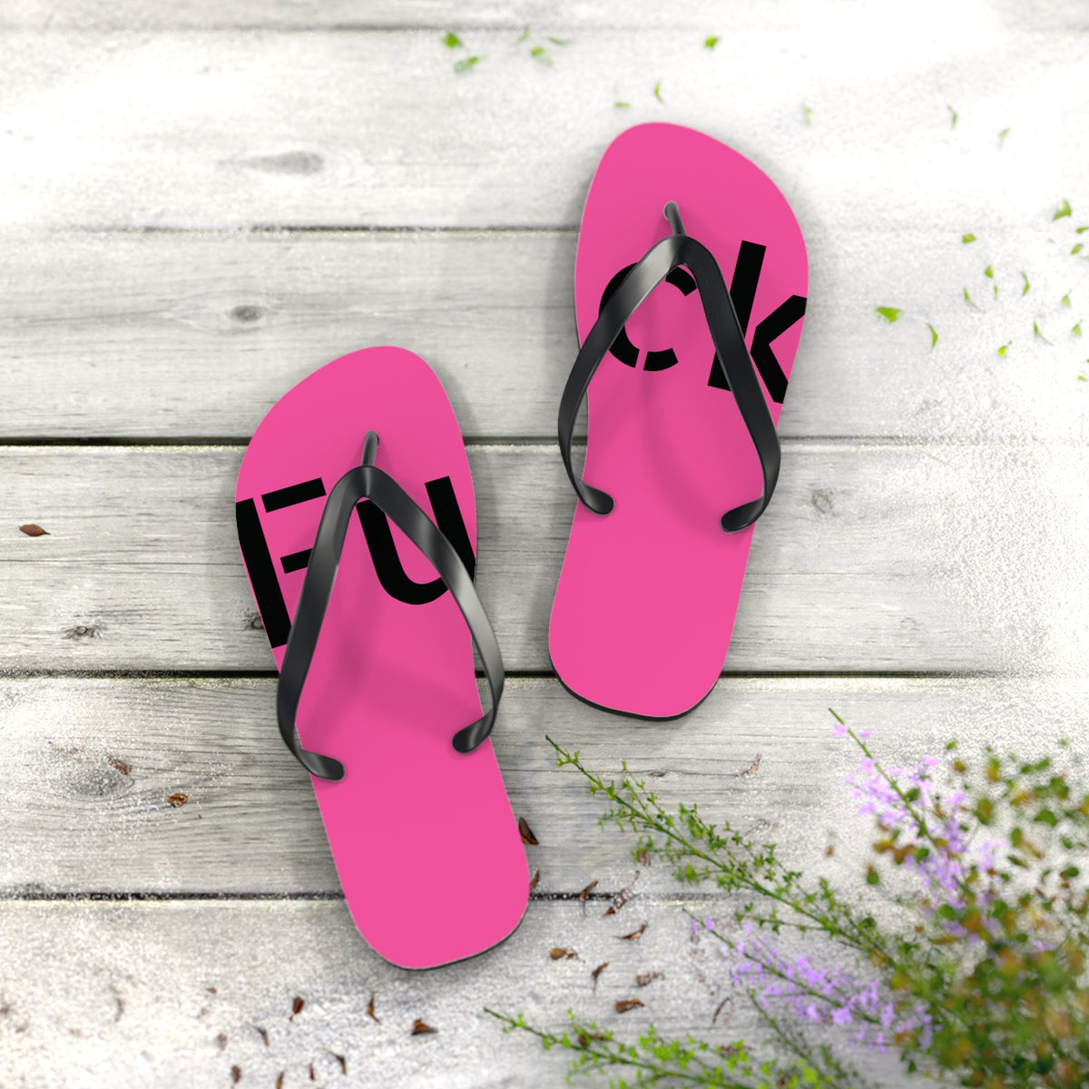 Bright pink flip-flops with black straps and large black FUCK lettering across both feet