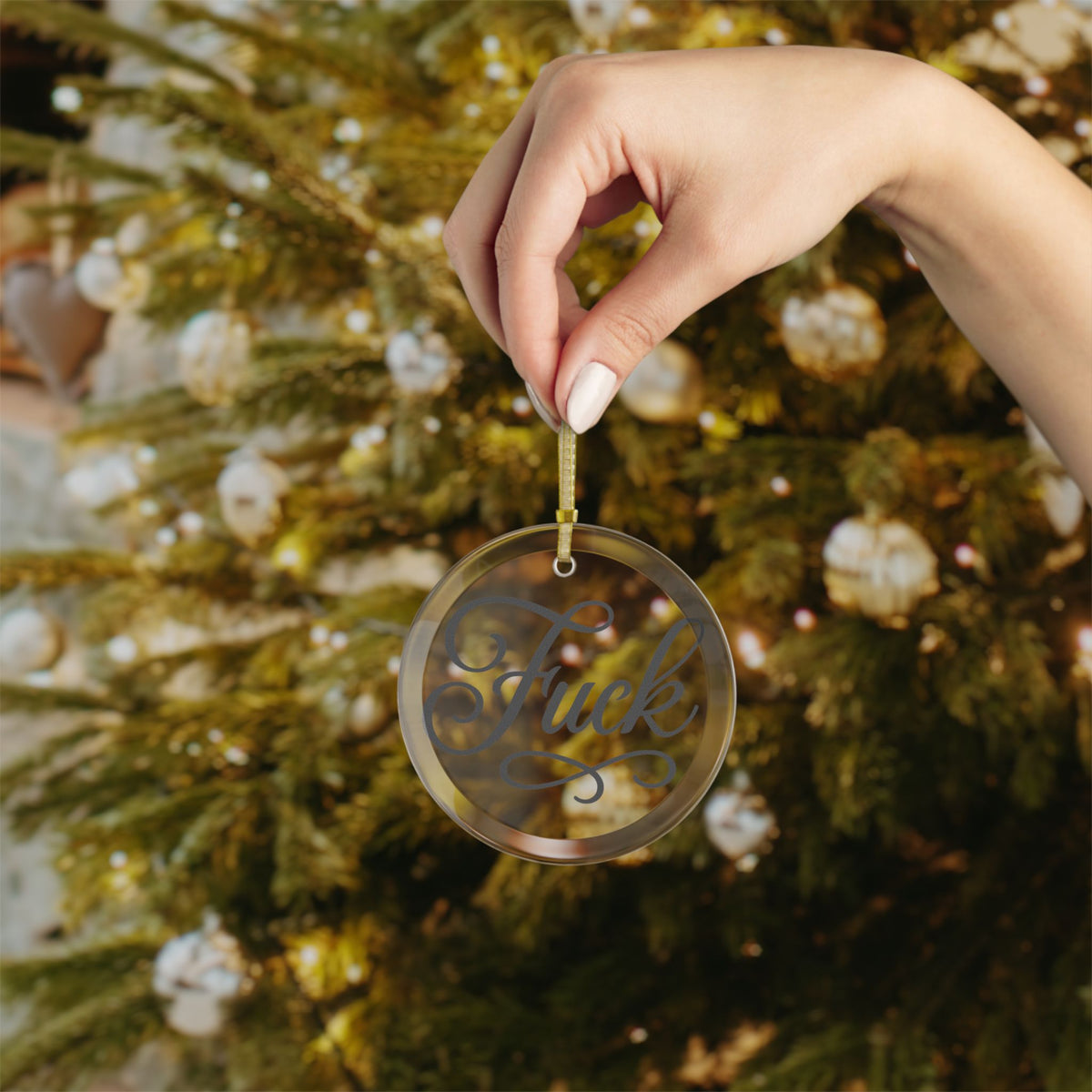 Clear round glass ornament with black script FUCK lettering and gold ribbon