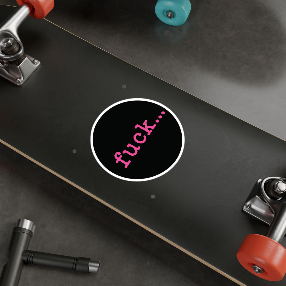 Round black vinyl sticker with lowercase motel-pink fuck and an ellipsis
