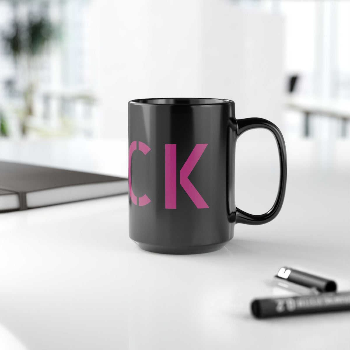 Glossy black 15-ounce mug with oversized motel-pink FUCK typography wrapping around it
